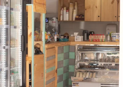 Interior de La Casa del Jardín, con vitrina de pastelería y refrigerador de bebidas