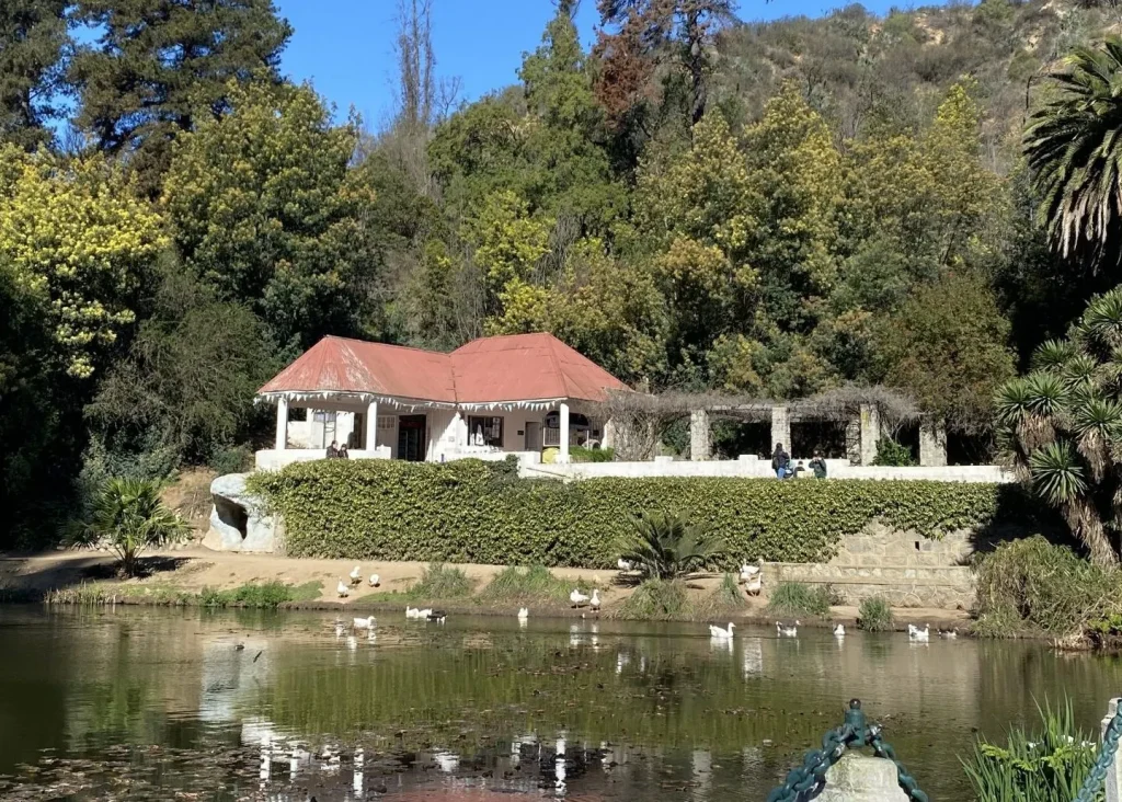 La Casa del Jardín, de techo rojo, vista desde el otro lado de la laguna