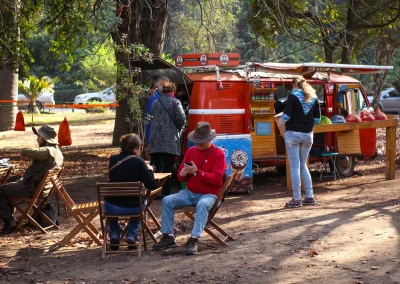 Visitantes sentados en sillas plegables junto al furgón de Combi Coffee