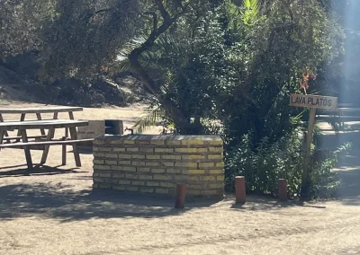 Parrilla de ladrillo y mesa junto a un letrero de lavaplatos